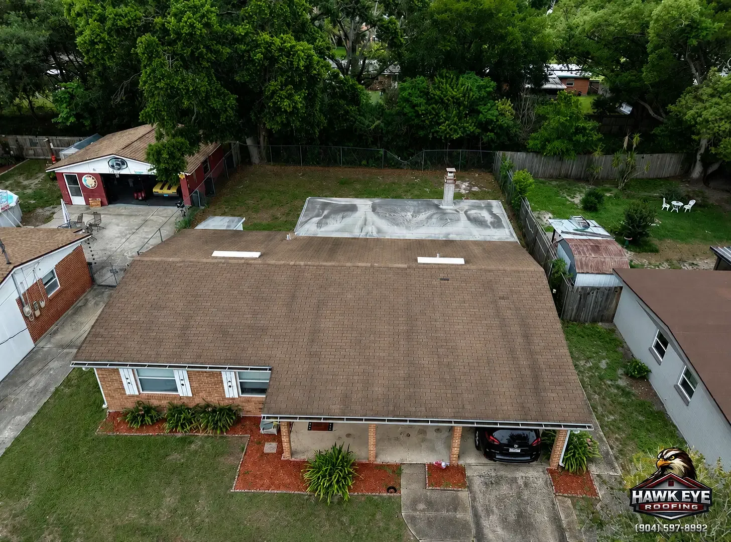 Aerial view of a completed brown shingle roof on a brick home in the Jacksonville area