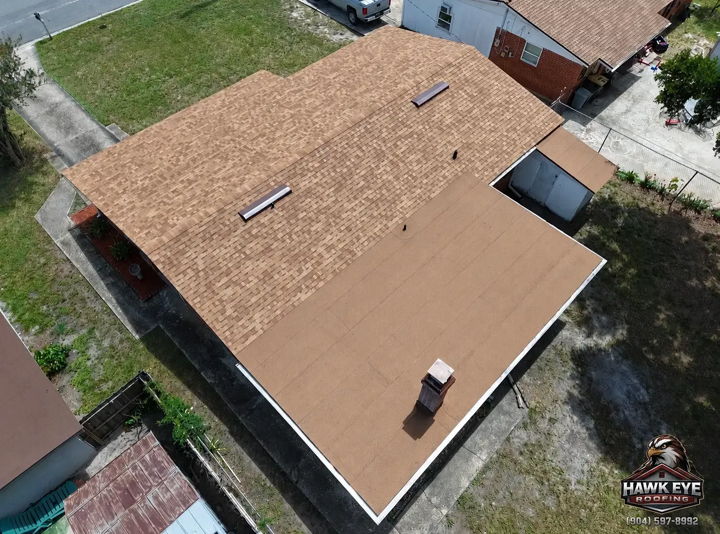 Close aerial view of roof vents and pipe penetrations on a tan shingle roof in the Jacksonville area