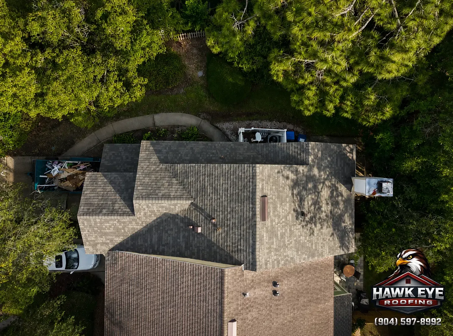 Aerial view of a tan shingle roof on a Northeast Florida home shaded by mature trees