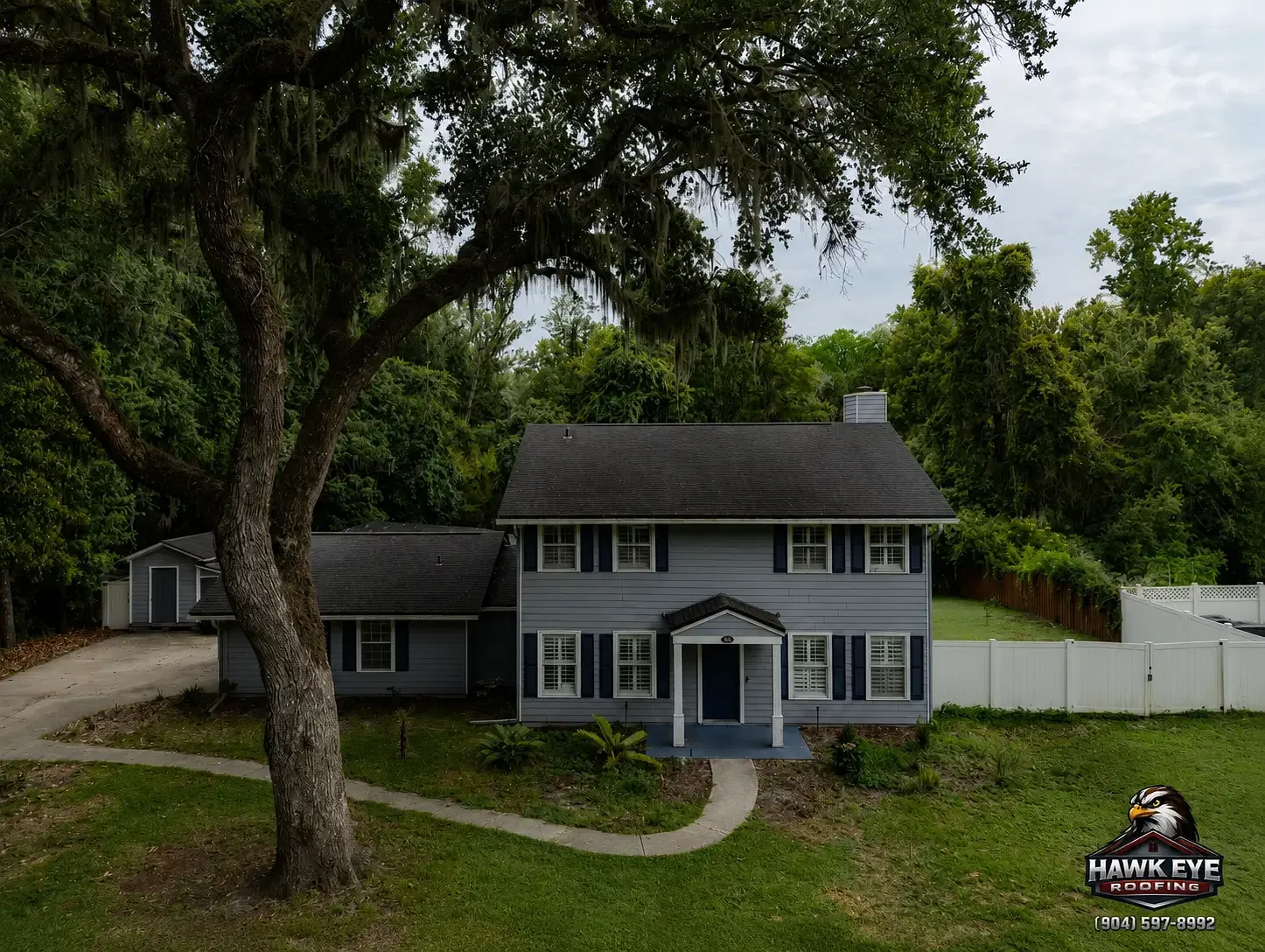 Two-story Jacksonville-area home with a brick chimney at the roofline, photographed during a Hawk Eye Roofing drone inspection
